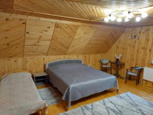 - une chambre avec un lit dans une pièce dotée de murs en bois dans l'établissement Holiday Home La Vіta, à Yaremtche