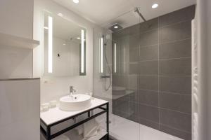a bathroom with a sink and a shower at Hôtel Riva Art & Spa in Menton