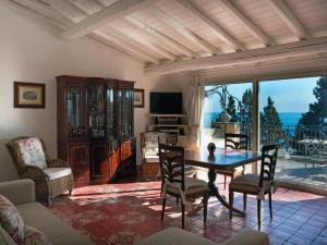 ein Wohnzimmer mit einem Tisch und Stühlen sowie einem Balkon in der Unterkunft Sea and the City in Taormina
