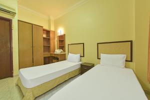 Ліжко або ліжка в номері OYO HOME 90700 Teluk Batik Holiday Apartment