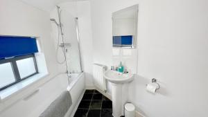 a white bathroom with a sink and a shower at Cross Court, Stafford by BELL Apartments in Stafford