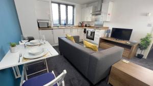 a kitchen and living room with a couch and a table at Cross Court, Stafford by BELL Apartments in Stafford