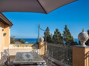 einen Balkon mit einem Tisch, Stühlen und Meerblick in der Unterkunft Sea and the City in Taormina