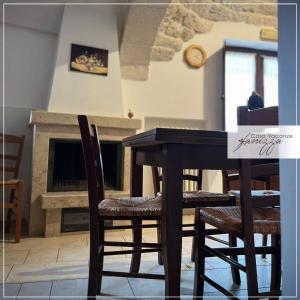 une salle à manger avec une table, des chaises et une cheminée dans l'établissement Trullo Cometa, à Alberobello