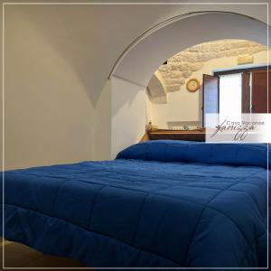 - une chambre avec un lit bleu et une voûte dans l'établissement Trullo Cometa, à Alberobello