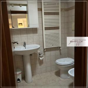 uma casa de banho com um lavatório, um WC e um espelho. em Trullo Cometa em Alberobello