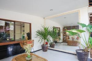 a room with potted plants and a mirror at Kampung 168 in Jimbaran