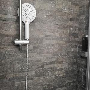 a shower head in a bathroom with a brick wall at Soulmate Rooftop Apartment in Rome +16 photos