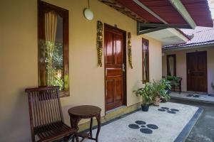 a porch with a chair and a wooden door at Kampung 168 in Jimbaran