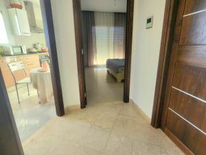 a room with a door and a kitchen with a table at Accueillant S+1 jardin de carthage in Tunis