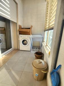 a laundry room with a washing machine and a window at Accueillant S+1 jardin de carthage in Tunis