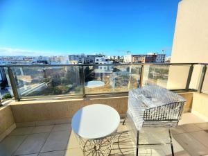 a white table and chairs on a balcony with a view at Accueillant S+1 jardin de carthage in Tunis +1 photo