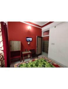 Hotel Diamond, Jammu في جامو: غرفة بها سرير وتلفزيون على الحائط