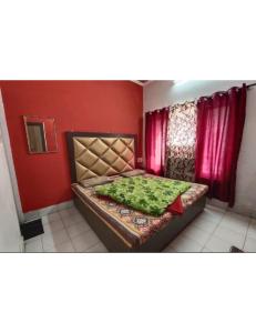 Schlafzimmer mit einem Bett mit roten Wänden und roten Vorhängen in der Unterkunft Hotel Diamond, Jammu in Jammu
