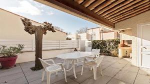 - une table et des chaises blanches sur la terrasse dans l'établissement Perles du Soleil- 50- Maison mezzanine- 6 pers, au Cap d'Agde