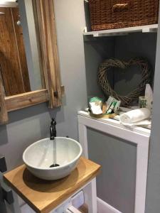 a bathroom with a bowl sink and a mirror at Cute studio cottage. Wood burner. Amazing views in Longhope
