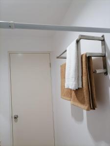 a bathroom with towels on a towel rack next to a door at Modena Town Square-Walkup Condominium in Minglanilla