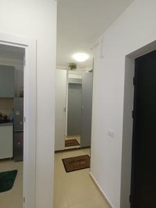 a room with a hallway with white walls and a kitchen at Garsoniera Monique Luxury in Chiajna +4 photos
