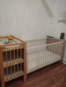 a crib in a room with a wooden table at Ferienwohnung mit Elbwiesenblick in Lutherstadt Wittenberg