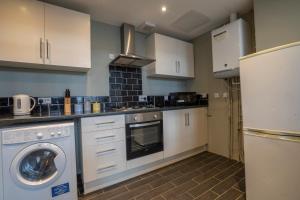 a kitchen with white cabinets and a washer and a refrigerator at 2 Bed-Town Centre-Free Parking in Old Walker +23 photos
