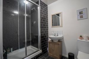 a bathroom with a glass shower and a sink at 2 Bed-Town Centre-Free Parking in Old Walker