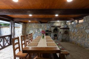 długi drewniany stół w pokoju z kamienną ścianą w obiekcie Садиба На Перевалі w mieście Jabłonica