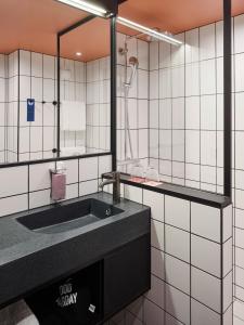 a bathroom with a sink and a mirror at Tribe Paris Saint Ouen in Saint-Ouen