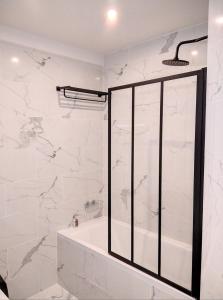 a bathroom with a shower with white marble walls at Résidence Armorial in Juan-les-Pins