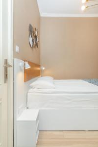 MY HOTEL في بورجومي: سريرين في غرفة بجدران بيضاء
