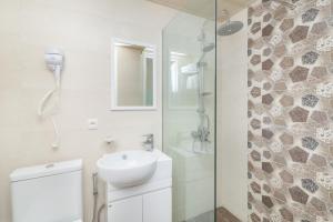 a white bathroom with a sink and a shower at MY HOTEL in Borjomi