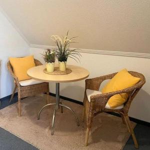 a table with two chairs and a yellow pillow on it at Restaurant San Marco in Ammerndorf