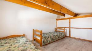 a bedroom with two bunk beds in a house at Cristallines- 89- Maison mezzanine- 6 pers in Cap d'Agde