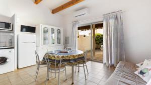 a kitchen with a table and chairs in a room at Cristallines- 89- Maison mezzanine- 6 pers in Cap d'Agde