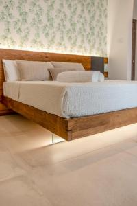 a bed with a wooden frame in a room at Sarmenti Agriresort in Otranto