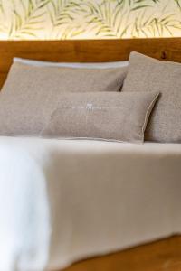 Una cama blanca con dos almohadas encima. en Sarmenti Agriresort en Otranto