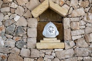 una pared de piedra con una pequeña ventana en una casa de piedra en Sarmenti Agriresort, en Otranto