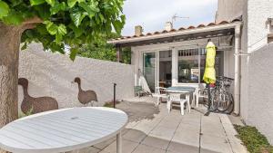 patio ze stołem, krzesłami i rowerem w obiekcie Sun Village- 39- Maison duplex- 6 pers w Cap d'Agde +2 zdjęcia