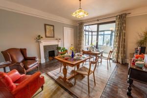 een woonkamer met een tafel en stoelen en een open haard bij Nutsford House in Dulverton