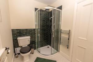 a bathroom with a toilet and a glass shower at Nutsford House in Dulverton