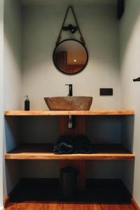 a bathroom with a sink and a mirror on the wall at Les cabanes des Pierreux in Gesves