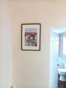 a picture hanging on a wall next to a toilet at Family friendly home Saltburn with Seaview in Skelton
