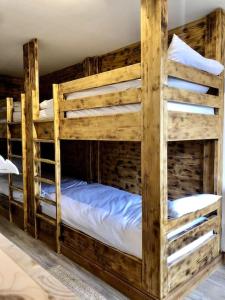 2 łóżka piętrowe w pokoju z drewnianymi ścianami w obiekcie Apartment Bourg St Maurice w mieście Bourg-Saint-Maurice