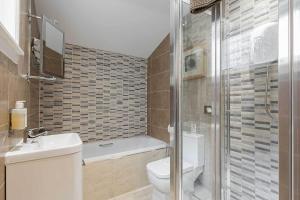 a bathroom with a toilet and a sink and a shower at Carmel Apartments in Falkirk