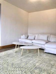 a living room with a white couch and two tables at Apartment Bourg St Maurice in Bourg-Saint-Maurice