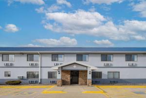 a large white building with a door in a parking lot at Super 8 by Wyndham Danville in Danville