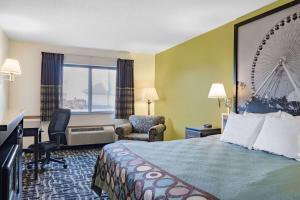 um quarto de hotel com uma cama grande, uma secretária e uma cadeira em Super 8 by Wyndham Danville em Danville