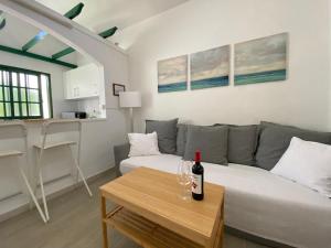 a living room with a couch and a bottle of wine on a table at Bungalow Einstein in Maspalomas