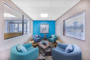 a waiting room with blue chairs and a table at Days Inn by Wyndham Fredericksburg North in Fredericksburg