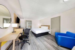a hotel room with a bed and a desk and chair at Days Inn by Wyndham Fredericksburg North in Fredericksburg