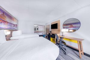 a hotel room with a large bed and a desk at Days Inn by Wyndham Fredericksburg North in Fredericksburg